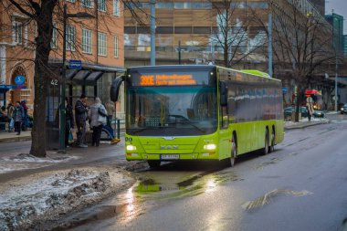 Oslo, Norveç - 26 Mart 2018: Parlak yeşil otobüs Oslo şehir merkezinde otobüs durağında bekleyen açık görünüm