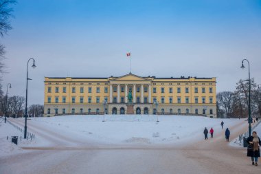 Oslo, Norveç - 26 Mart 2018: Açık kimliği belirsiz kişi Kraliyet Sarayı önünde yürüyüş görünümünü Norveç'te 19. yüzyılın ilk yarısında inşa edilmiş