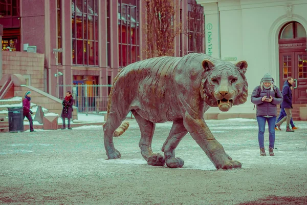 OSLO, NORUEGA - MARÇO, 26, 2018: Vista ao ar livre de turistas perto de uma enorme estátua de tigre de bronze na cidade cente é muito popular entre e tem um apelido entre os noruegueses, Tiger City — Fotografia de Stock