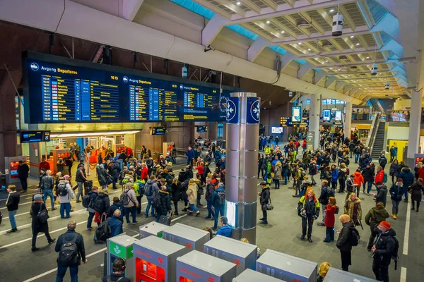 OSLO, NORUEGA - 26 DE MARZO DE 2018: Multitud de personas revisando la hora de salida dentro de la estación central de tren de Oslo, hay 19 vías de salida con tecnología moderna — Foto de Stock