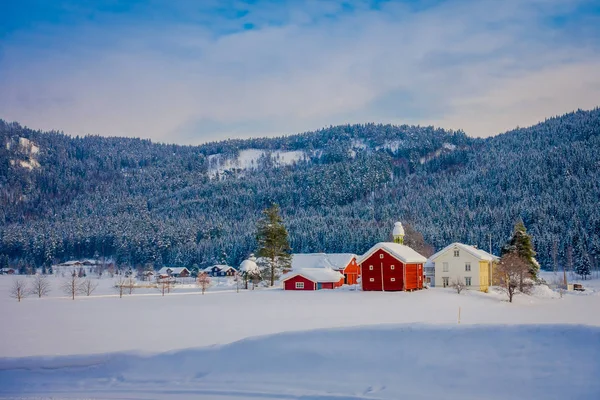 Sorprendente vista al aire libre de las tradicionales casas rojas de montaña noruegas de madera cubierta de nieve en el techo en impresionante fondo de montaña naturaleza en Noruega — Foto de Stock