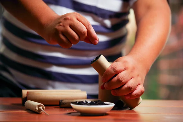 Κοντινό πλάνο του ανθρώπου προετοιμασία καφέ firecracker κοντά στο μπολ με τα μπαρούτι, πάνω από ένα ξύλινο τραπέζι — Φωτογραφία Αρχείου