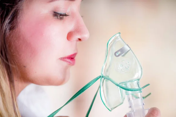 Portrét mladé ženy pomocí rozprašovač pro astma a onemocnění dýchacích cest doma — Stock fotografie