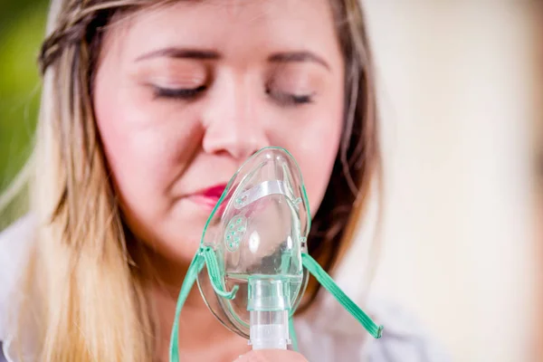 Retrato de mujer joven usando nebulizador para asma y enfermedades respiratorias en el hogar — Foto de Stock