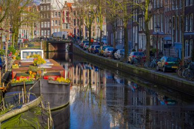 Amsterdam, Hollanda, Mart, 10 2018: Güzel açık manzaralı evler ve Amsterdam kanal gemilerde donmuş nehir, sabah fotoğraf su yansıması ile Hollanda tarzı renkli evlerin