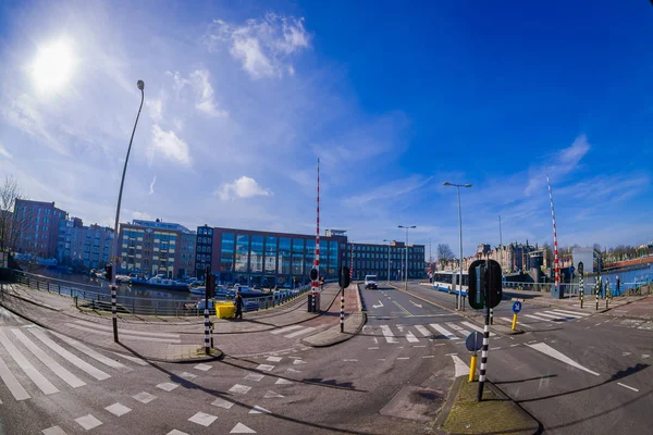 Άμστερνταμ, Ολλανδία, 10 Μαρτίου 2018: Εξωτερική άποψη από τους δρόμους κοντά στα κανάλια του Άμστερνταμ, είναι η πρωτεύουσα και η πιο πυκνοκατοικημένη πόλη της Ολλανδίας σε όμορφη ηλιόλουστη μέρα — Φωτογραφία Αρχείου