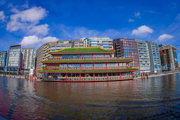 アムステルダム、オランダ、2018 年 3 月 10 日: 外装ダブルツリー バイ ヒルトン ホテルの中央駅の近くで撮影アジア アムステルダムの川沿いの建物 — ストック写真