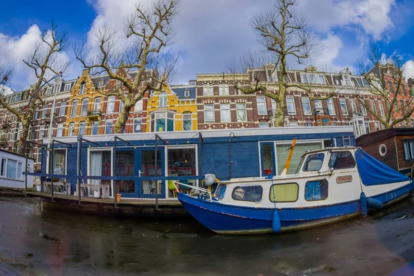 AMSTERDÃO, PAÍSES BAIXOS, MARÇO, 10 2018: Vista ao ar livre de barcos e prédios de apartamentos atrás em um canal na cidade de Amsterdã — Fotografia de Stock