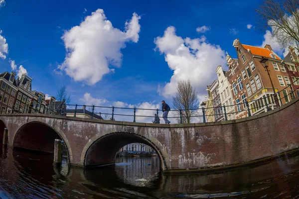 Amsterdam, Niederlande, märz, 10 2018: blick von außen auf amsterdam kanäle mit menschen, die über eine brücke und typische holländische häuser gehen. Holland — Stockfoto