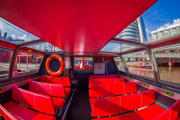 Amsterdam, Nederland, maart, 10 2018: Indoor weergave van rode excursie boot of cruise schip op Amsterdamse water gracht in het centrum van Amsterdam, Amstel rivier. Toeristische boot met toeristen — Stockfoto