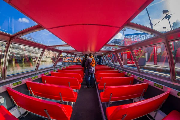 AMSTERDAM, PAYS-BAS, 10 MARS 2018 : Vue intérieure d'un bateau d'excursion rouge ou d'un bateau de croisière sur le canal d'Amsterdam dans le centre d'Amsterdam, rivière Amstel. Bateau touristique avec touristes — Photo