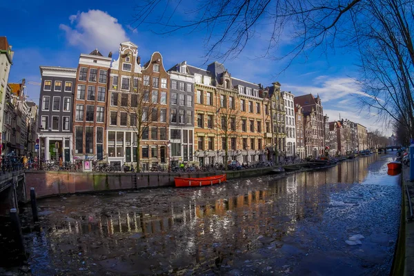 АМСТЕРДАМ, НИДЕРЛАНДЫ, МАРТ, 10 МАРТА 2018: Катера и лодки на Амстердамском канале. Утреннее фото цветных домов в голландском стиле с отражением в воде — стоковое фото