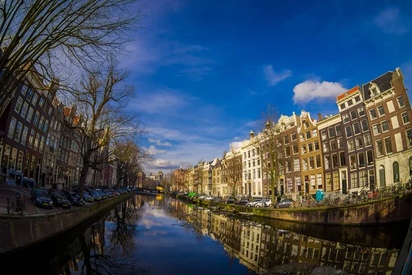 АМСТЕРДАМ, НИДЕРЛАНДЫ, 10 МАРТА 2018 г.: Открытый вид на дома и лодки на Амстердамском канале. Утреннее фото цветных домов в голландском стиле с отражением в воде — стоковое фото