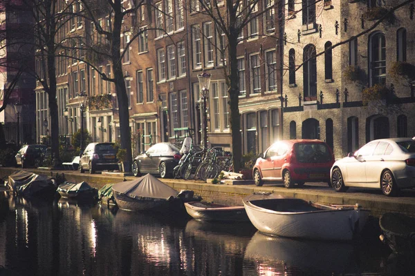 Amsterdam, Niederlande, märz, 10 2018: atemberaubender blick auf häuser und boote auf dem amsterdam kanal, im holländischen stil mit reflexion im wasser — Stockfoto