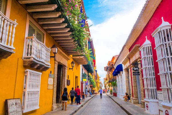 CARTAGENA, COLÔMBIA, OUTUBRO, 30, 2017: Pessoas não identificadas andando e tirando fotos na rua da cidade de Cartagena com prédio colorido de Cartagena Walled City — Fotografia de Stock