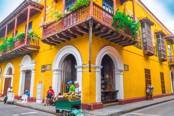 CARTAGENA, COLOMBIA, 30 DE OCTUBRE DE 2017: Personas no identificadas caminando y tomando fotos en la calle de la ciudad de Cartagena con colorido edificio de la ciudad amurallada de Cartagena —  Fotos de Stock