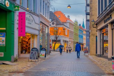 Bergen, Norveç - 03 Nisan 2018: sakin bir yan sokakta şehrin iyi korunmuş 19. yüzyıl mimarisinde genellikle bulutlu bir günde yürüyüş tanımlanamayan kişi