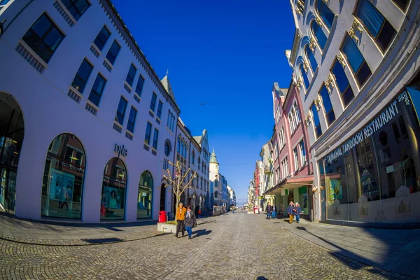 ALESUND, NORWAY - APRIL 04, 2018: People walking in the streets of Alesund town on the west coast of Norway, at the entrance to the Geirangerfjord, with a gorgeous blue sky — Stock Photo, Image