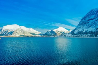Açık görüş sırasında mavi bir gökyüzü Hurtigruten yolculukta kar kaplı büyük dağ sahil sahneleri muhteşem manzara