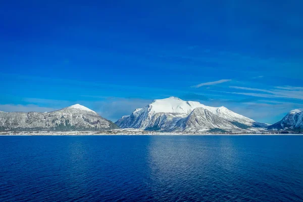 Paesaggio incredibile di vista esterna di scene costiere di montagna enorme coperta di neve durante il viaggio Hurtigruten durante un cielo blu — Foto Stock