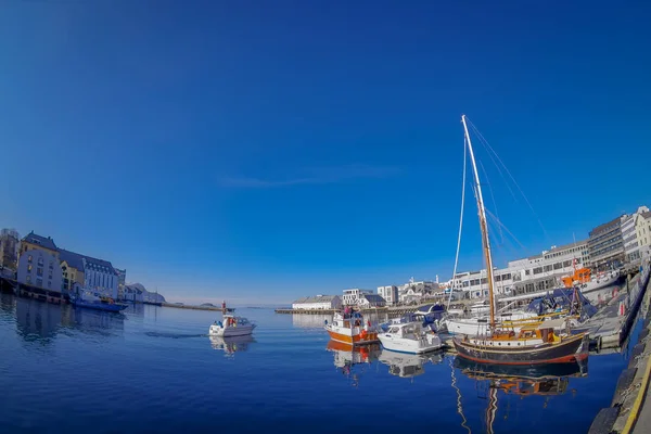 ALESUND, NORUEGA - 04 DE ABRIL DE 2018: Vista al aire libre de la ciudad portuaria de Alesund en la costa oeste de Noruega, con algunos barcos navegando a la entrada del Geirangerfjord en un hermoso cielo azul —  Fotos de Stock