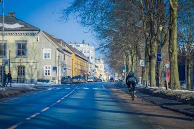 Trondheim, Norveç - 06 Nisan 2018: Açık yol geleneksel İskandinav binalar tribünde Trondheim çevreleyen park edilmiş araba ile görünümünü