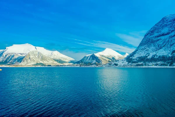 Atemberaubende Küstenlandschaft mit riesigen schneebedeckten Bergen auf hurtigruten während der Fahrt in blauem Himmel — Stockfoto