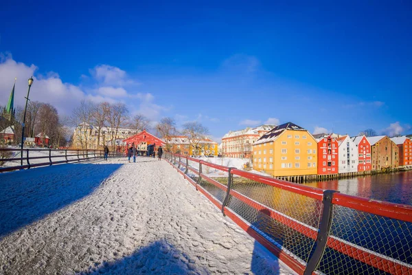 TRONDHEIM, NORUEGA - 04 DE ABRIL DE 2018: Hermosa vista al aire libre del viejo puente de madera Gamle Bybro con algunos edificios de madera de colores en la orilla del río Nidelva en Trondheim, Noruega — Foto de Stock