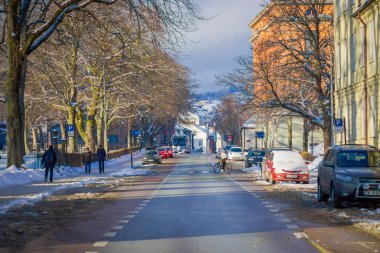 Trondheim, Norveç - 04 Nisan 2018: Açık bir kaldırım bazı arabalar yakın yürüyüş kimliği belirsiz kişi görünümünü Trondheim geleneksel İskandinav binalarda sokakta park edilmiş