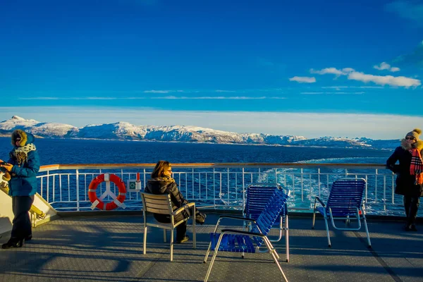 Alesund, Νορβηγία - 09 Απριλίου 2018: Εξωτερική άποψη των αγνώστων ατόμων κάθεται και απολαμβάνοντας το τοπίο σε Hurtigruten ταξίδι με πλοίο κατά μήκος ακτή της Νορβηγίας — Φωτογραφία Αρχείου
