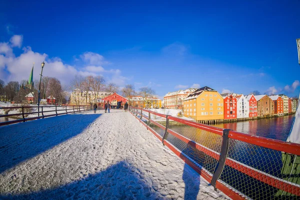 TRONDHEIM, NORUEGA - 04 DE ABRIL DE 2018: Hermosa vista al aire libre del viejo puente de madera Gamle Bybro con algunos edificios de madera de colores en la orilla del río Nidelva en Trondheim, Noruega — Foto de Stock