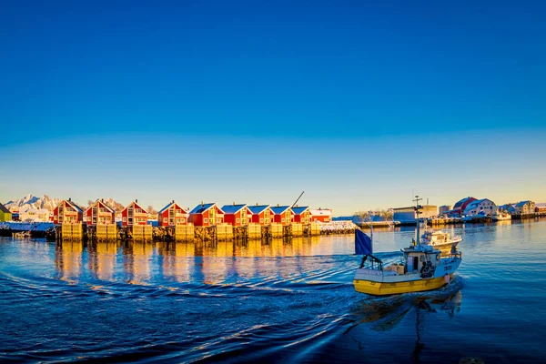 SVOLVAER, ILHAS LOFOTEN, NORUEGA - 10 de abril de 2018: Paisagem de edifícios da aldeia Svolvaer à beira-mar com barcos navegando, durante um dia ensolarado com céu azul claro nas ilhas Lofoten — Fotografia de Stock