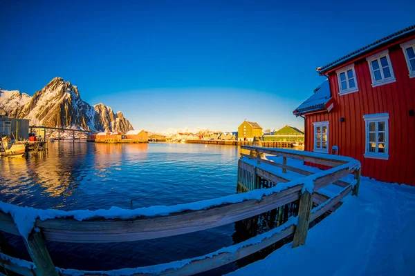 SVOLVAER, LOFOTEN ISLANDS, NORWAY - APRIL 10, 2018: Beautiful rorbu or fishermans houses in a port with some buildings in the horizont in Svolvaer Lofoten Islands — Stock Photo, Image