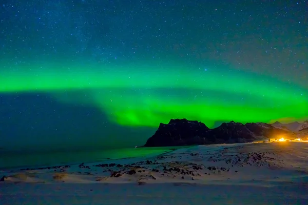 Krásný obraz obrovské zelené pulzující Aurora Borealis, také známý jako polární záře na noční obloze nad Lofoten ostrovy — Stock fotografie