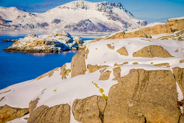 Крупный план таяния снега над огромной скалой на открытом воздухе в снежную зиму в Полярном круге — стоковое фото