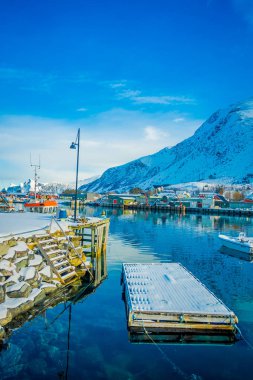 Henningsvaer, Norveç - 04 Nisan 2018: Açık bakış balıkçı limanı ahşap kayan yapısı ve küçük balıkçı tekneleri Lofoten Adaları