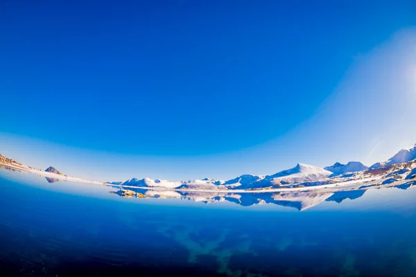 Häpnadsväckande vacker utsikt över bergstopparna och reflektion i vattnet på Lofoten öarna i Norge — Stockfoto