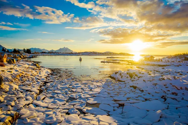 Vista incrível do pôr do sol com pequenos e médios pedaços de gelo deixados para trás durante uma maré baixa em um lago congelado — Fotografia de Stock