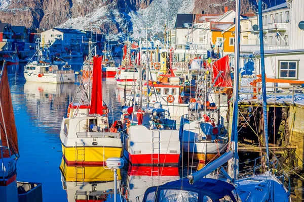 Henningsvaer, Noruega - 04 de abril de 2018: Porto de pesca pitoresco em Henningsvaer, com edifícios típicos de madeira vermelha e pequenos barcos de pesca nas ilhas Lofoten, Noruega — Fotografia de Stock