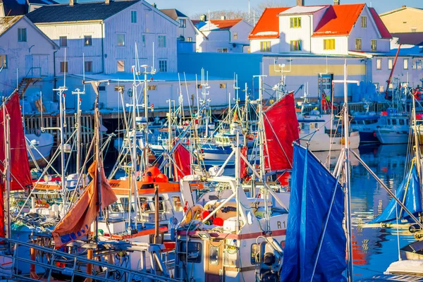 Henningsvaer, Noruega - 04 de abril de 2018: Pintoresco puerto pesquero en Henningsvaer con edificios típicos de madera roja y pequeños barcos de pesca en las islas Lofoten, Noruega — Foto de Stock