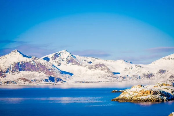 Vista all'aperto di enormi montagne coperte di neve e splendido lago blu in inverno nevoso nel Circolo Polare Artico — Foto Stock