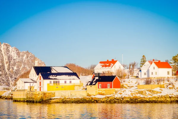 Vista ao ar livre de um porto em Henningsvaer com edifícios típicos de madeira vermelha nas ilhas Lofoten — Fotografia de Stock