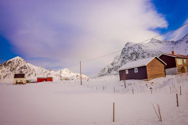ヘニングスヴァールにある、ロフォーテン諸島の冬の季節の間に雪で覆われた木造住宅で典型的な村に屋外の表示 — ストック写真