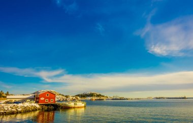 Henningsvaer, Norveç - 04 Nisan 2018: Bay shore Lofoten Adaları durring teknesi ile ahşap binanın açık görünümü güzel bir güneşli gün