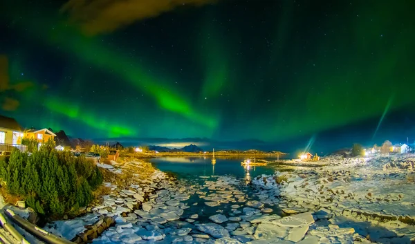 Amazing outdoor view of green aurora borealis in the sky during night and small and medium pieces of Ice left behind during a low tide on a frozen lake — Stock Photo, Image