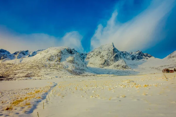 Vacker utomhus utsikt över vit snö täckt marken med frusen sjö och enorma berg bakom på vintern vid Polcirkeln i lofoten island — Stockfoto