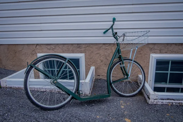 Vue extérieure des vélos à rouleaux ou scooters amish s'appuient contre une maison — Photo