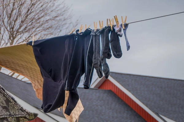 Vista esterna di vestiti di asciugatura Amish al sole e aria dopo la lavanderia con uno sfondo di legno rosso casa a Lancaster — Foto Stock