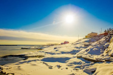 Bay karlı dağlarda ve renkli kış ile çevrili adalar istasyonu ve gökyüzünde parlak güneş Lofoten bazı binaların açık görünüm