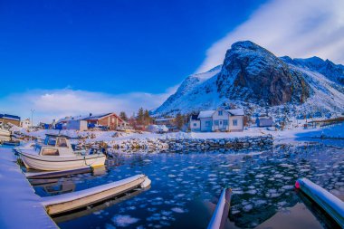 Svolvaer, Lofoten Adaları, Norveç - 10 Nisan 2018: balıkçı teknesi Harbour bazı binanın arkasında ve büyük dağ Svolvaer, Lofoten Adaları ilçe kar ile kaplı açık görünüm